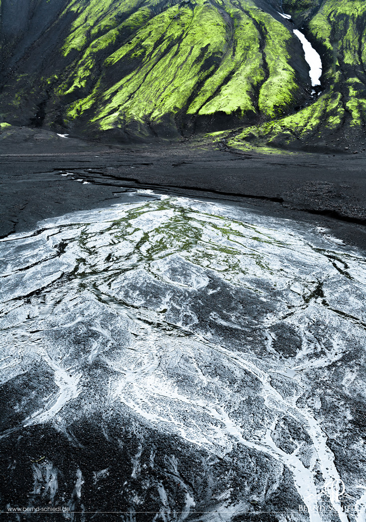 Fluoreszierendes grünes Moos, schwarzer Basalt und blauer Himmel am Langisjór